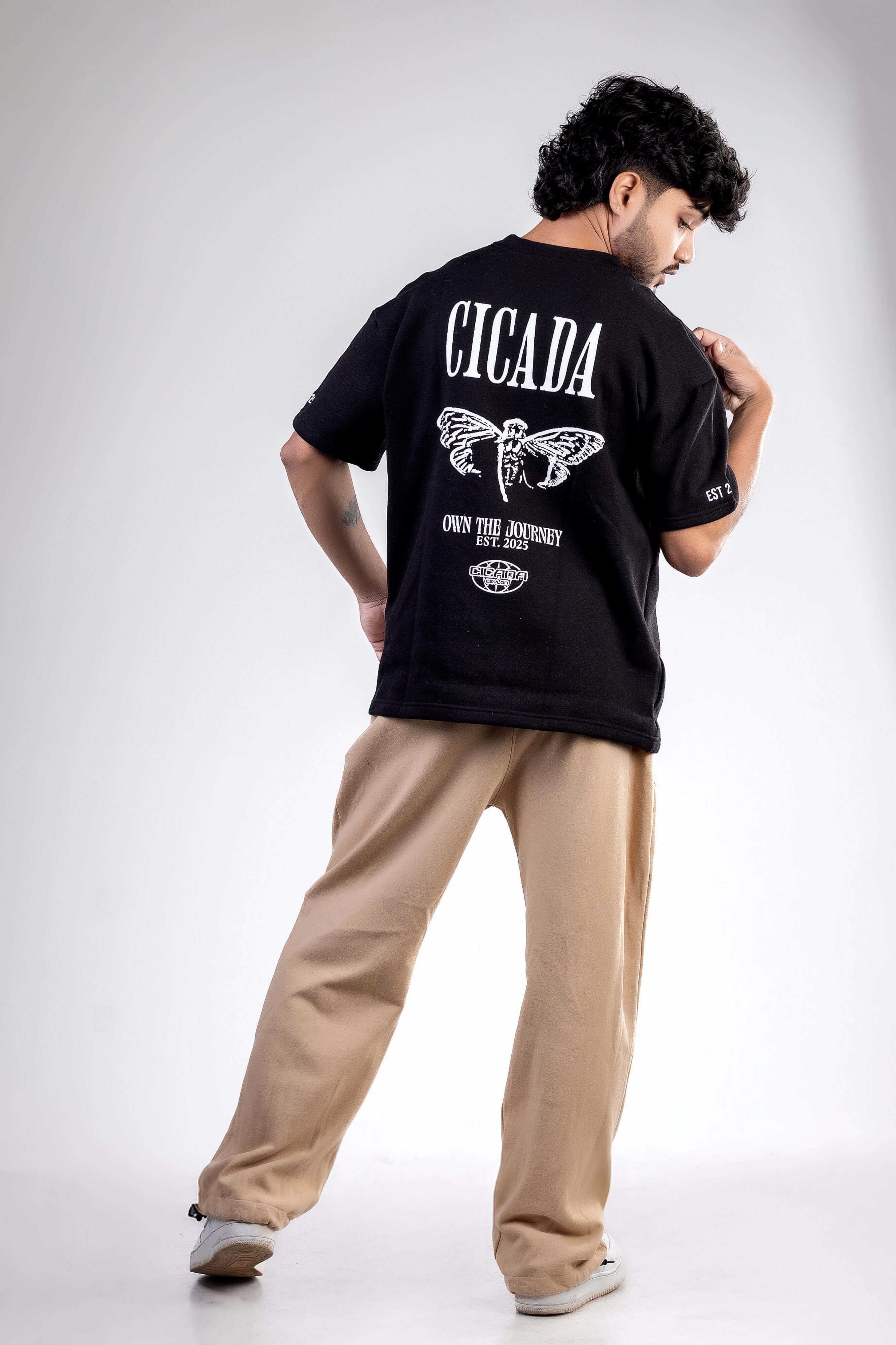 CICADA ONE t-shirt featuring a bold print on the back, model wearing it in a casual setting.CICADA ONE t-shirt